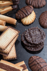 Cookies assorted on black background. Delicious morning snacks for breakfast, brunch and lunch. Appetizing, sweet and fast food.
