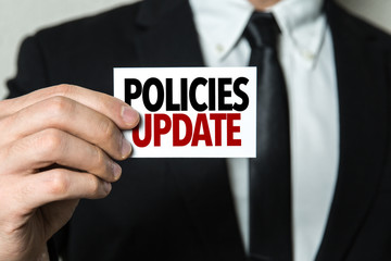 Business man holding a card with the text: Policies Update