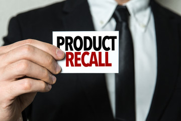 Business man holding a card with the text: Product Recall