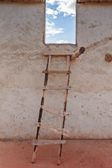Old wooden ladder near the house wall