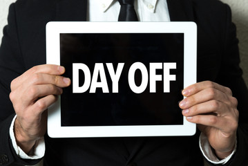 Business man holding a tablet with the text: Day Off