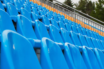 Rows of blue and orange chairs on a soccer stadium