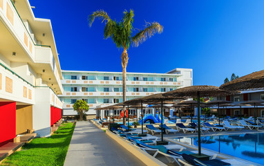 Fototapeta na wymiar courtyard of a modern hotel with pool and sunbeds