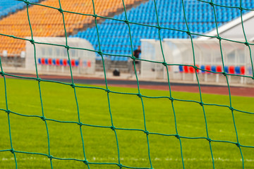 Obraz premium View of the stadium through the soccer goal net