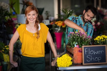 florist standing while male arranging flower 