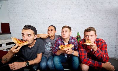 Friends watching TV with surprise, eating pizza close-up. Fans w