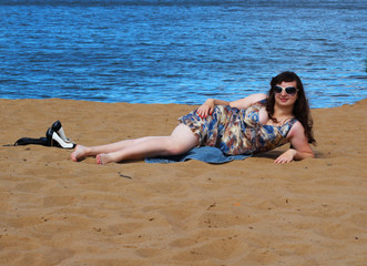 Girl lying on a sandy beach.