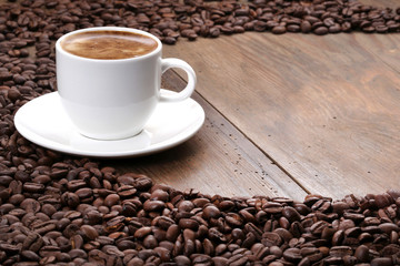Coffee cup and coffee beans on a wooden table