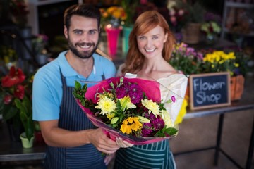 Portrait of couple holding flower bouquet