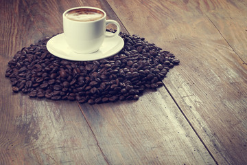 Coffee cup and coffee beans on a wooden table