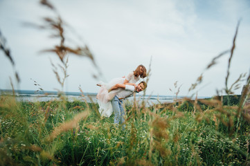 Happy Bride and groom walking on the green grass
