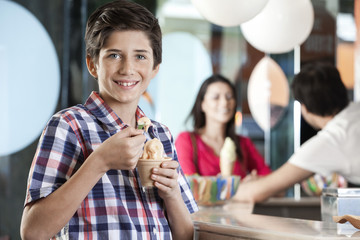 Smiling Preteen Boy Having Ice Cream At Parlor