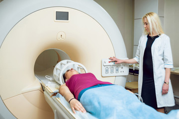 Medical equipment. Doctor and patient in MRI room at hospital.