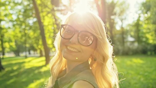 Young charming girl with blonde hair flirts and smiles on a summer day. Slow motion.