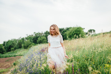 Fototapeta na wymiar beautiful girl in white dress lies in green grass
