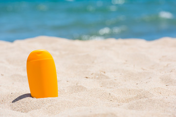 Fototapeta na wymiar Sunscreen bottle on the beach