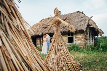 large handmade doll amulet near a wooden house