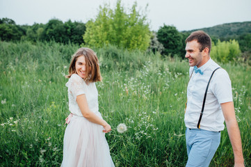 Happy Bride and groom walking on the green grass