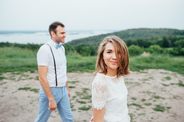 Obraz premium Happy Bride and groom walking on the green grass