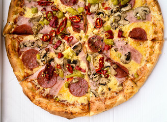 Italian pepperoni pizza with ham, red peppers and cheese