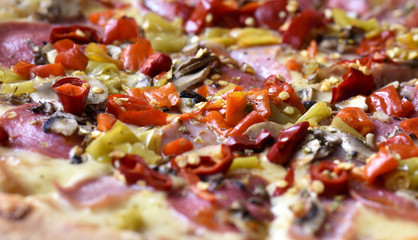 Italian pepperoni pizza with ham, red peppers and cheese