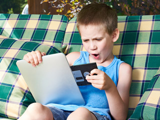 Little boy with floppy disk and tablet pc