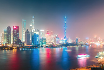 Obraz na płótnie Canvas Aerial panoramic view over a big modern city by night. Shanghai, China. Nighttime skyline with illuminated skyscrapers.