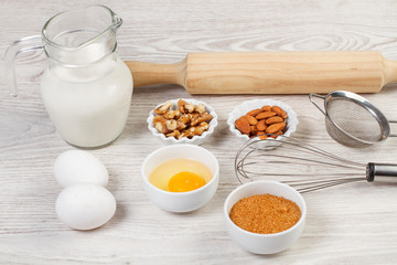 Leche, huevos y frutos secos sobre un fondo de madera blanca rústica. Vista de frente y de cerca