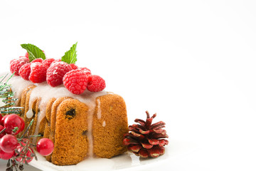 Christmas fruit cake with raspberries on white background

