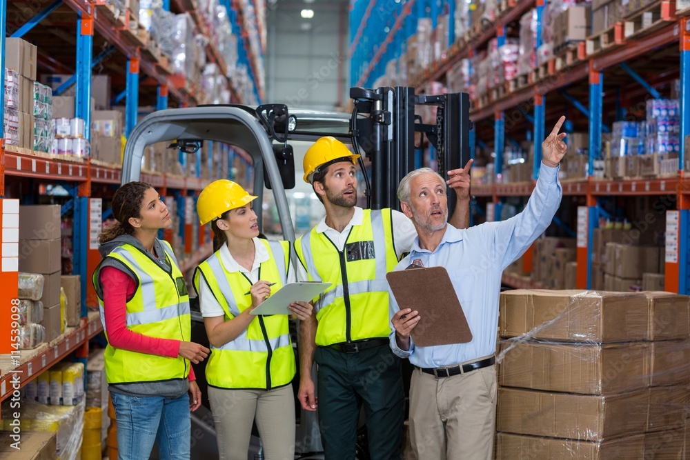 Poster manager and workers are looking shelves and pointing