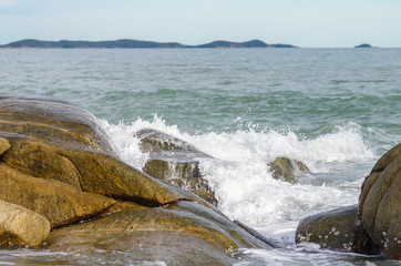 Wave crashing on rock beach