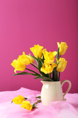 Bouquet of yellow tulips on a pink background