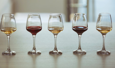 Many glasses of different wine in a row on a table