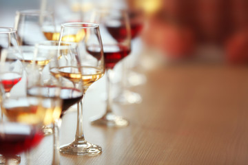Many glasses of different wine in a row on a table