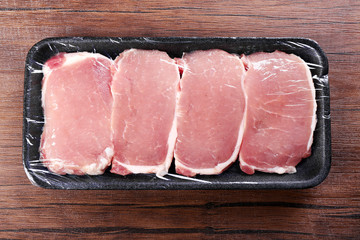 Packed pieces of pork meat on wooden background