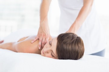 Midsection of masseuse giving massage to woman