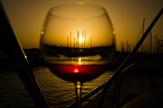 Sunset over marina with fine glass of wine