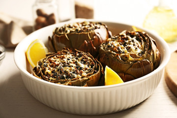 Tasty backed artichoke on a white plate, close up