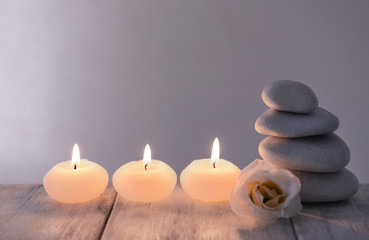 Fototapeta na wymiar White spa stones with candles on dark background