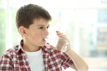Cute boy drinking water on kitchen