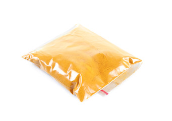 Powdered turmeric in plastic zipper bag, isolated on white