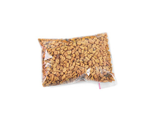 Fenugreek seeds in plastic zipper bag, isolated on white