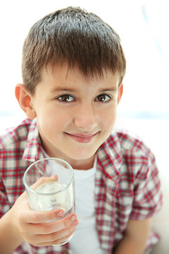 Cute boy drinking water on kitchen