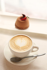 Cup of coffee with chocolate dessert on white table