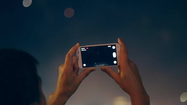 Man filming colorful fireworks on his cell phone.
Filming fireworks. HD.