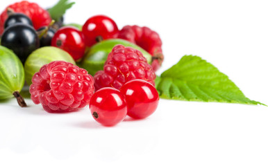 A mixture of ripe juicy fruits and berries on a white background. Raspberries, currants, gooseberries close-up. Beautiful fruit background