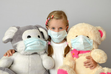 portrait of a sick child in a medical mask with a soft toy