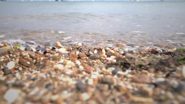Close up of waves lapping up onto a stone and shingle beach. Footage taken Southend on Sea which is in Essex United Kingdom