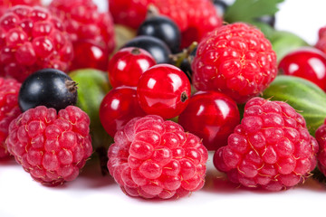 A mixture of ripe juicy fruits and berries on a white background. Raspberries, currants, gooseberries close-up. Beautiful fruit background