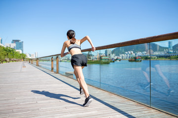 Back view of woman running on boardwalk